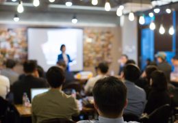 Audience Watching a Presentation. Defocused Blurred Presenter During Conference Meeting